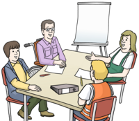 Vier Personen sitzen an einem Tisch.  Einer von ihnen ist im Rollstuhl. Auf dem Tisch liegen ein Ordner, Kullis und Papiere. Die Personen sprechen miteinander.